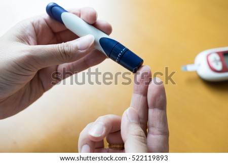 Medicine, diabetes, glycemia, health care and people concept - close up of man hands checking blood sugar level by Glucose meter