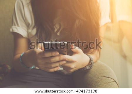 Young woman sitting using smartphone in coffee cafe, urban women lifestyle technology, vintage style