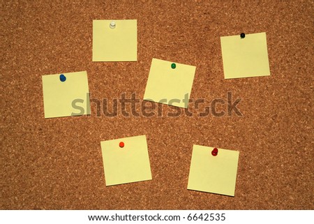 cork board with six empty yellow notes