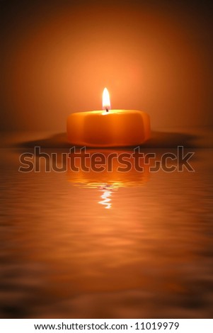 christmas candle and reflection in water