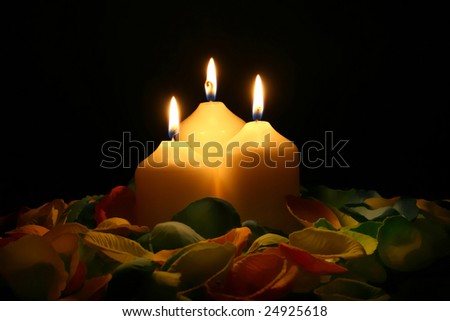 three candles with warm and magic light in black background