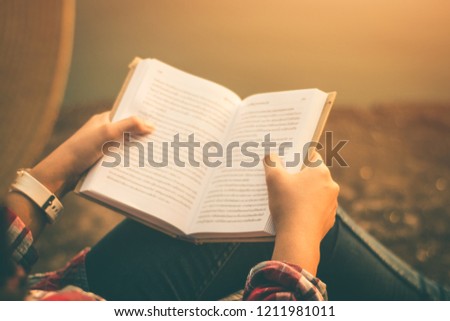 Women tourists read book in quiet nature.