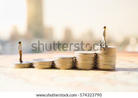 Miniature people: Small figures standing on stack of coin. Money and financial concepts.