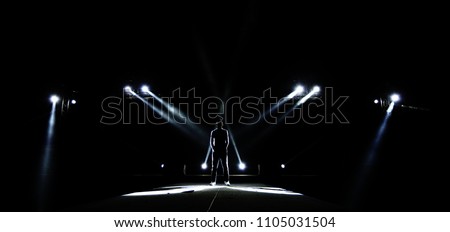 Performance moving lighting on construction light beam ray downward to Man on Stage as Leader Superstar, Silhouette of Male surround with Light, Dark Low Exposure, concept Unique Confidence
