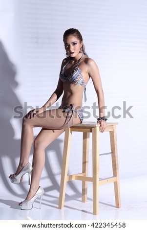 Asian Thai Female Woman Model Tan Skin in Grey Dot Bikini Sport Swim wear Suit Wet Hair, Studio Lighting Shadow on White Background, Sexy Pose sit on wooden stool Full body, contrast shadow concept