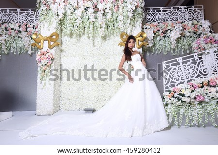 Perfect Slim Body Bride in Tan skin wedding dress over Flower background and screen in studio lighting, concept copy space for text