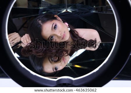 Clear and Smooth Skin Asia Thai Girl with night time make up in studio lighting with mirror reflect herself