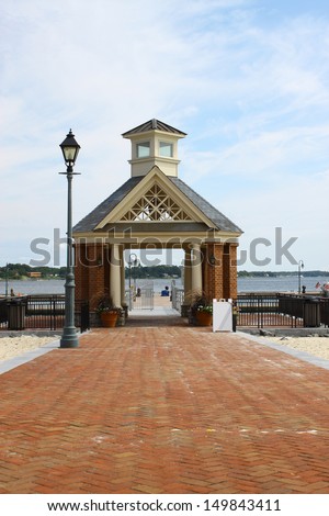 A brick walkway through a large Gazebo leading to the waterfront pier and boat dock landing along the riverwalk landing in Yorktown Virginia