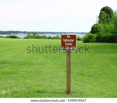 A no vehicular traffic sign in the grass field overlooking the york river and Gloucester point Virginia on a sunny summer day