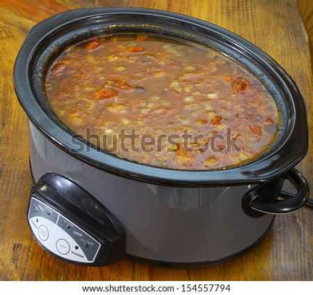 A fresh pot of Chili beans also known as chili con carne being cooked on a wooden table