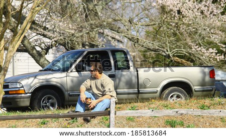 GLOUCESTER, VA - April 5, 2014: A Man sitting on top of a hill with his Wawa coffee watching and awaiting for the parade to arrive, The Daffodil fest and Parade is a regular event held each spring