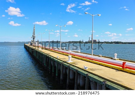 Shipping fuel delivery lines leading out on and old wooden pier into the York river in Yorktown Virginia for coast guard, Naval and other shipping vessel fueling needs.