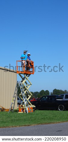 MIDDLESEX, VA - SEPTEMBER 27, 2014: Hummel Air Field landing crew staff on a scissor jack above the field helping direct the incoming & outgoing planes  at the air field and runway in Middlesex VA