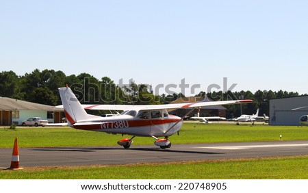 MIDDLESEX, VA - SEPTEMBER 27, 2014: A small red & white private plane headed up the runway at Hummel field in the wings wheels and keels annual show at the Hummel airfield airstrip in Middlesex VA