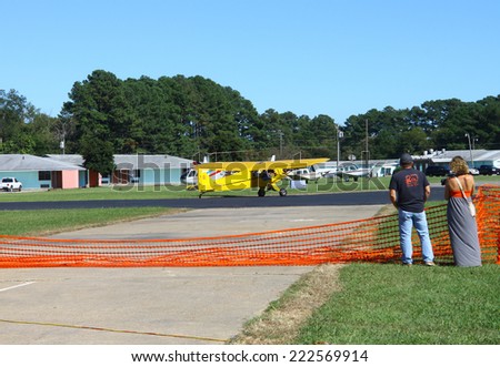 MIDDLESEX, VA - SEPTEMBER 27, 2014: An unknown couple watching the planes at hummel field airport runway in the wings wheels and keels annual show at the Hummel airfield airstrip in Middlesex VA
