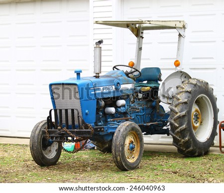 GLOUCESTER, VA - JANUARY 2 2015:A Old Ford tractor outside a garage in Virginia, The First Ford tractor was made in 1916, Ford sold its tractor division In 1991 and stopped using the Ford name by 2000