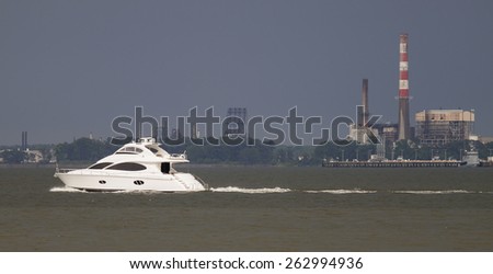 A cabin cruiser boat headed out to the Chesapeake Bay by way of the York River in Virginia during an approaching thunderstorm on a warm humid summer day