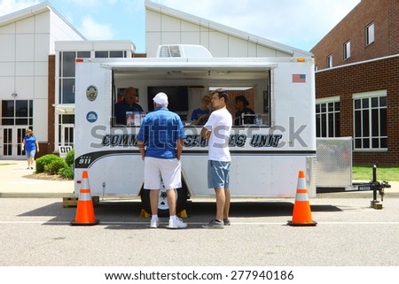 WILLIAMSBURG, VA - May 9, 2015: Spectators at the James City County community services trailer at the 6th Annual Project Lifesaver Car Show in Williamsburg Virginia on a summer day.
