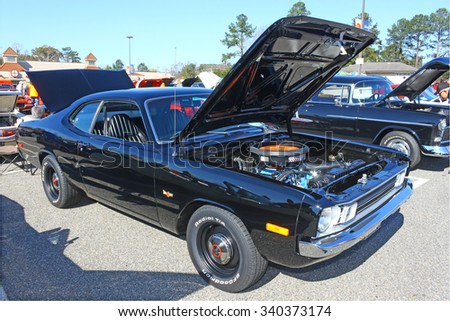 GLOUCESTER, VIRGINIA - NOVEMBER 14, 2015: A black Dodge Dart Demon in the annual Shop With \
a Cop Car Show held once each year to help benefit needy children of Gloucester for Christmas.