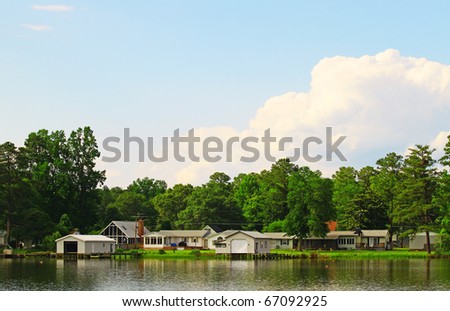 A summer waterfront landscape on a peaceful and calm river on a beautiful day outside with boathouses and room for your text