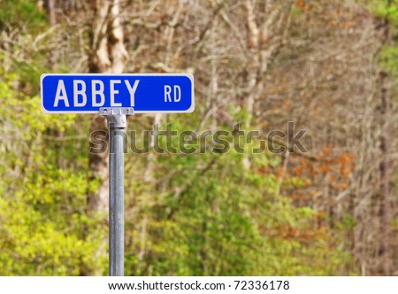 An Abbey road sign against the woods honoring the famed Beatles recording studio in London using selective focus and a shallow depth of field with room for your text.