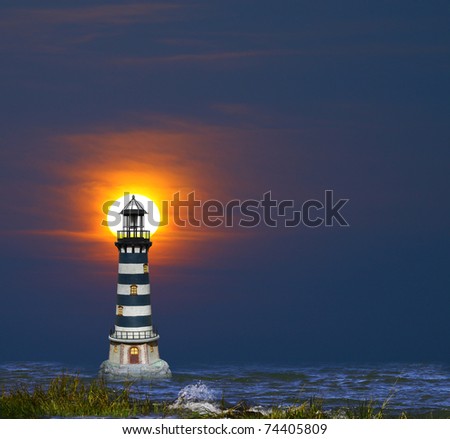 A lighthouse in the bay with the sun on fire through the clouds in the background as it is setting over the horizon.