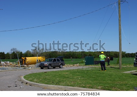 GLOUCESTER, VIRGINIA - APRIL 16: An unidentified electrician prepares to repair power lines on April. 16, 2011 after a tornado damaged lines and property in Gloucester, Virginia. An overturned and destroyed school bus lies in the distance.