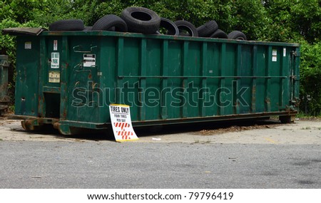 A large metal tire recycling dumpster outside for tire disposal to be recycled with room for your text.