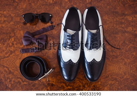 Groom shoes bowtie belt glasses and wedding rings
