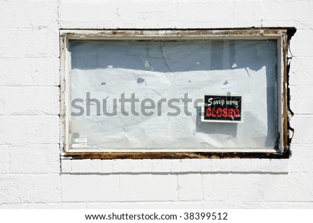 boarded up white window of bankrupt business with \