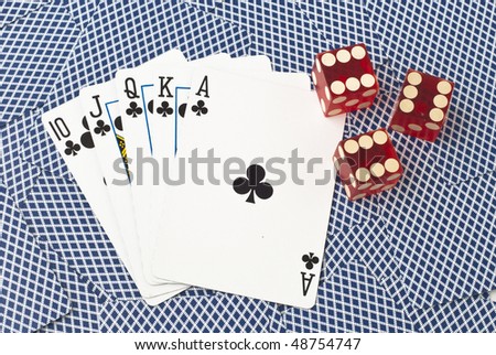 Five cards and three dice, showing a royal flush with clubs from ten to ace, on a background of backsides of blue playing cards. The dice all show number six