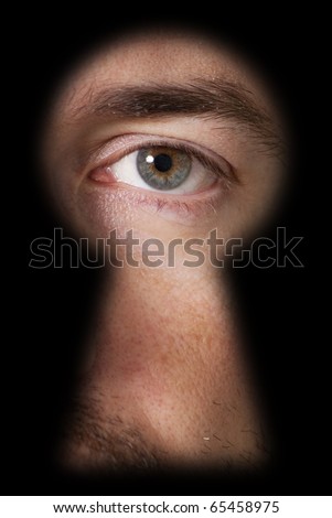 Male eye, looking through a blurry black keyhole