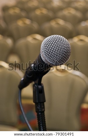 Microphone in front of several rows of empty chairs with shallow depth of field