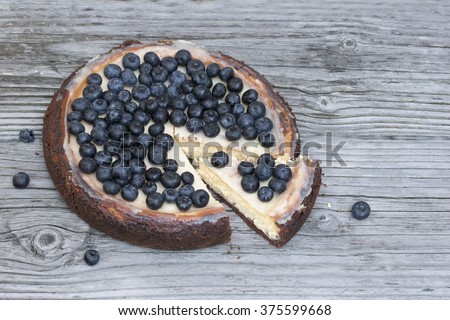 Sliced cheesecake New York  with blueberry / Sliced cheesecake New York with chocolate base and blueberry on a wood background