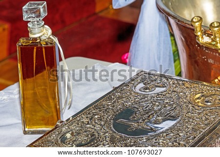 Oil bottle, font and holy book at Christening ceremony