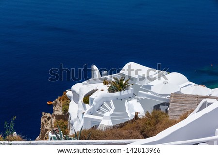 Beautiful stairs going down to a house built in the edge of the cliff at Oia, Santorini in Greece
