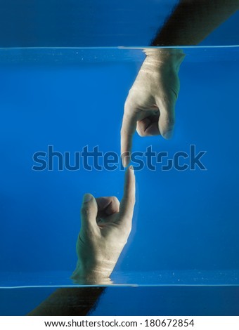Two hands touching each other, concept about the creation of life against a blue background