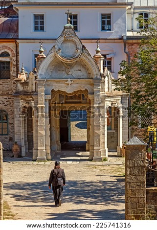 MOUNT ATHOS - MAY 22, 2014: Monk in black robe entering St. Andrew\'s Skete on Holy Mount Athos.  The Russian Skete of Saint Andrew is located not far from Karyes belongs to the Monastery of Vatopedi.