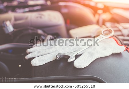 Selective focus on duty dirty glove with car engine with tools made with filter color effect.