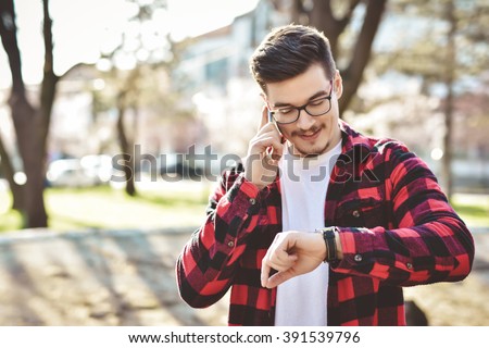 Young businessman worried looking at his wrist watch. Toned image