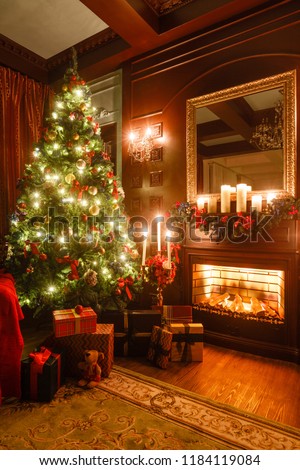 gifts at the Christmas tree. Christmas evening by candlelight. classic apartments with a fireplace.