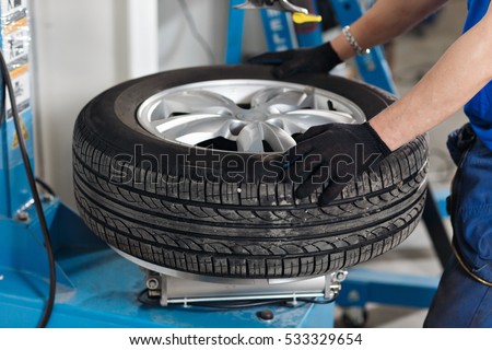 Mechanic removes car tire closeup. Machine for removing rubber from the wheel disc