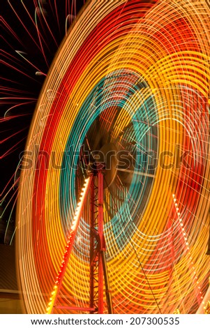 Ferris Wheel spins in front of a firework show