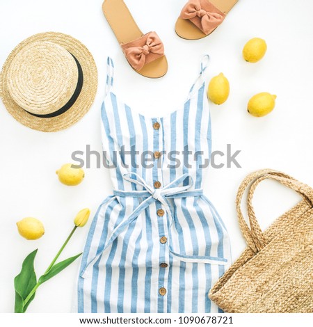 Summer female fashion stylish composition. Dress, slippers, straw, lemons, tulip flower and accessories on white background. Flat lay, top view.