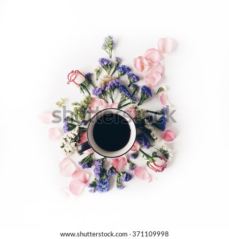 Cup of coffee with blue and pink flowers. Flat lay, top view