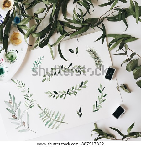 Workspace. Green leaves painted with watercolor isolated on white background. Overhead view. Flat lay, top view