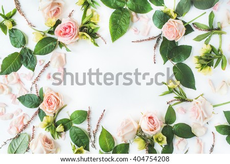 frame with pink roses, branches, leaves and petals isolated on white background. flat lay, overhead view
