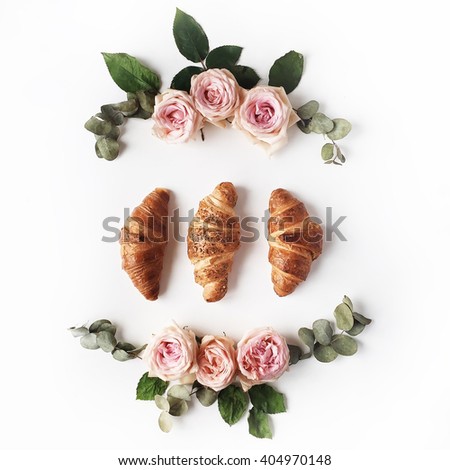 Breakfast with croissants, pink rose flower, petals composition. Flat lay, top view