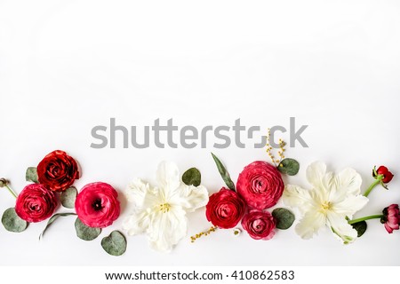 Pink and red roses or ranunculus, white tulips and green leaves on white background. Flat lay, top view
