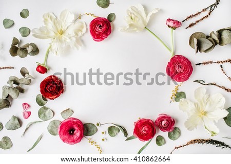 wreath frame with pink and red roses or ranunculus, white tulips and green leaves on white background. Flat lay, top view